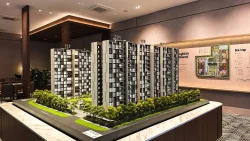 Scale model of Altura EC residential blocks with site map on showroom wall behind