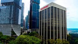 Southpoint office building beside modern high-rise glass towers with green trees in foreground