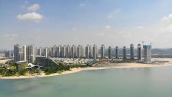 High-rise apartment blocks and low-rise housing along the coastline with a sandy beach in front