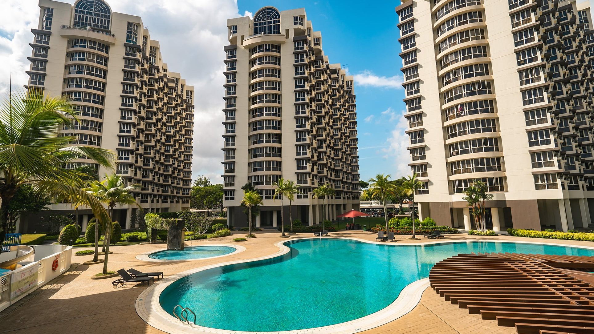 Bullion Park apartment blocks with large swimming pool and landscaped gardens under blue sky