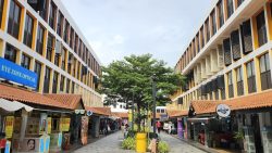 Shophouses with orange tiled roofs and three-storey yellow and white residential blocks with shutters and windows