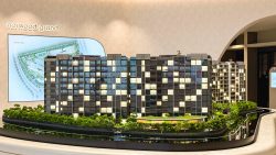 Norwood Grand residential model with multiple blocks, greenery, and site plan on wall behind