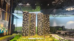LyndenWoods model with three residential blocks, landscaped grounds, and a pool in a showroom setting