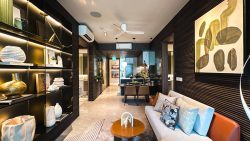 Living room and dining area in The Continuum with sofa, illuminated shelves, pendant lights and artwork