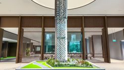 Scale model of Promenade Peak residential tower and surrounding landscaping inside a showroom