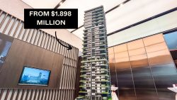Scale model of a high-rise residential building in showroom with pricing text from $1.898 million