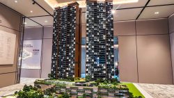Architectural scale model of two high-rise residential towers with landscaped podium in a showroom