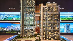 Model of One Marina Gardens residential blocks with illuminated windows and greenery on balconies