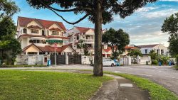 Corner terrace houses with red tiled roofs along a tree-lined street named Paya Lebar Cres
