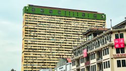 Yue Hwa Chinese products store in a heritage building with a tall yellow and green residential block behind it