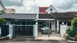 Single-storey terrace house with tiled roofs and a silver car parked behind a metal gate