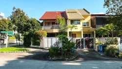 Two-storey terrace houses with gated driveways and greenery at a suburban street corner in daylight