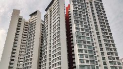 McNair Towers residential blocks rising against a cloudy sky with white and grey facades