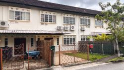 Two-storey terraced houses with barred windows, air conditioners and metal gates in front yards