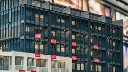 Model of modern residential blocks with multiple red "SOLD" signs on various unit windows