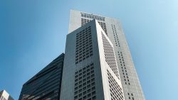Tall commercial buildings with glass and panelled façades against a clear blue sky