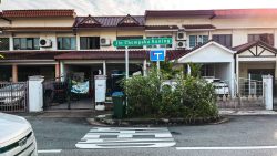 Two-storey terrace houses with red tiled roofs behind a street sign for Jln Chempaka Kuning and a no-through road sign