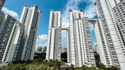 Tall white residential blocks with sky gardens connected by elevated sky bridges under a blue sky