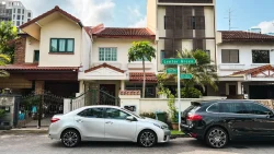 Two semi-detached houses with tiled roofs and cars parked along the street at Lentor Green road sign