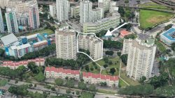 Cluster of high-rise residential blocks outlined in white with red-roofed terraced houses and school buildings nearby