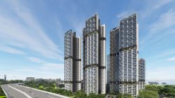 Tall residential apartment blocks beside a highway with greenery and cable cars in the background
