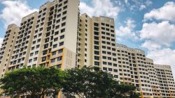 West Plains @ Bukit Batok residential blocks with cream and yellow facades against a blue sky with clouds and green trees