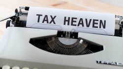 Paper in a typewriter with the words "TAX HEAVEN" typed on it