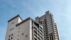 Housing blocks with block numbers 80 and 81 visible against a clear blue sky