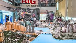 Detailed cityscape model of Singapore with people viewing it inside a modern exhibition space