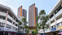 Clementi town centre sign with rows of shops and two tall residential blocks in the background
