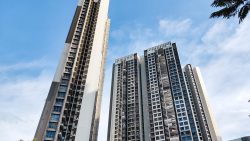 Trivelis Clementi DBSS residential blocks under a blue sky with some tree branches visible at edges