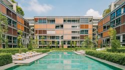 Meyer House apartment blocks with swimming pool, sun loungers, and landscaped greenery under blue sky