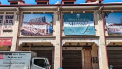Banners advertising Atlassia freehold residential and commercial mixed development on a shophouse facade