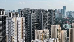 Cluster of modern high-rise residential blocks with a city skyline and greenery in the background