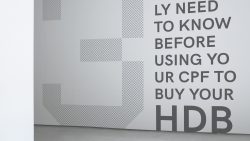 Wall text reading "What you really need to know before using your CPF to buy your HDB" with a patterned design on left
