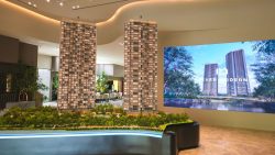 Detailed River Modern residential blocks scale model in showroom with digital screen of development and trees