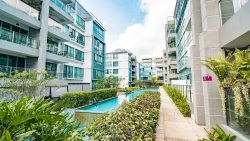 The Sixth Avenue Residences apartment blocks with a long swimming pool and landscaped greenery along the path