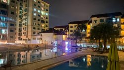 Changi Court apartment blocks illuminated at night with swimming pool and clubhouse in foreground