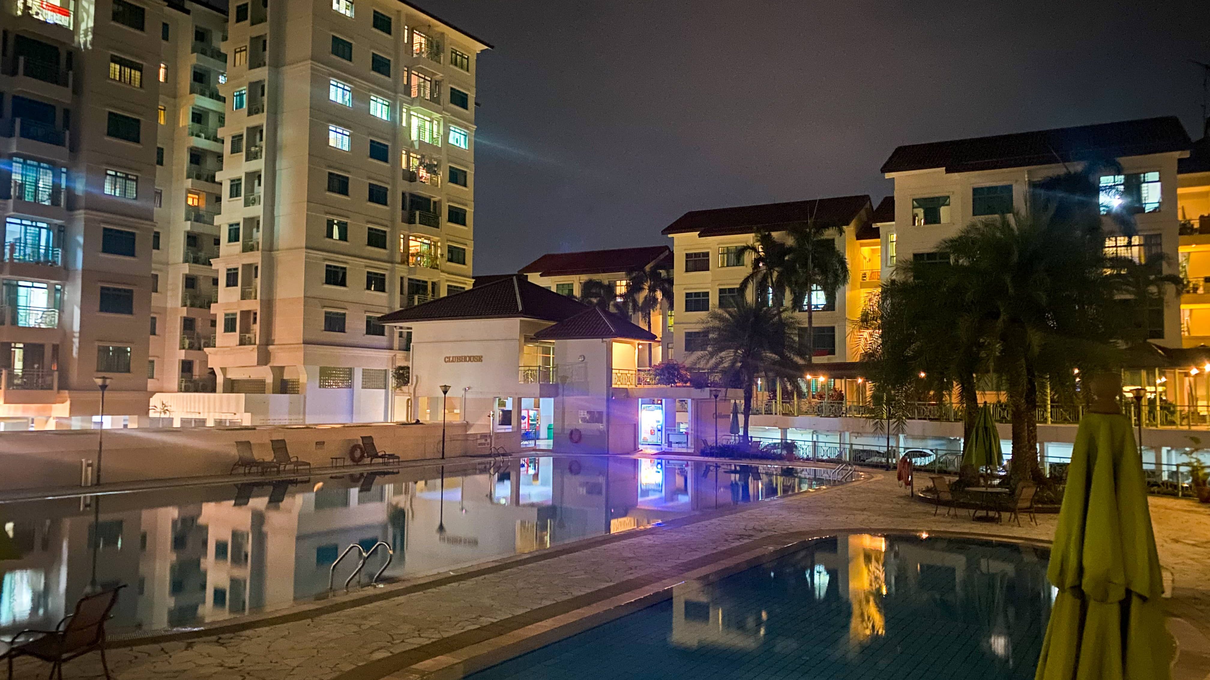Changi Court apartment blocks illuminated at night with swimming pool and clubhouse in foreground
