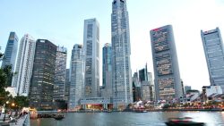 Central business district high-rise office towers lining the river with riverboats and evening lighting