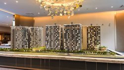 Grand Dunman scale model showing multiple residential blocks with greenery and roadside trees in showroom setting