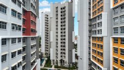 High-rise Bedok South Horizon residential blocks with grey, white, orange, and red façades and open windows