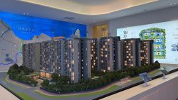 Model of Coastal Cabana apartment blocks with site plan and location map in the background