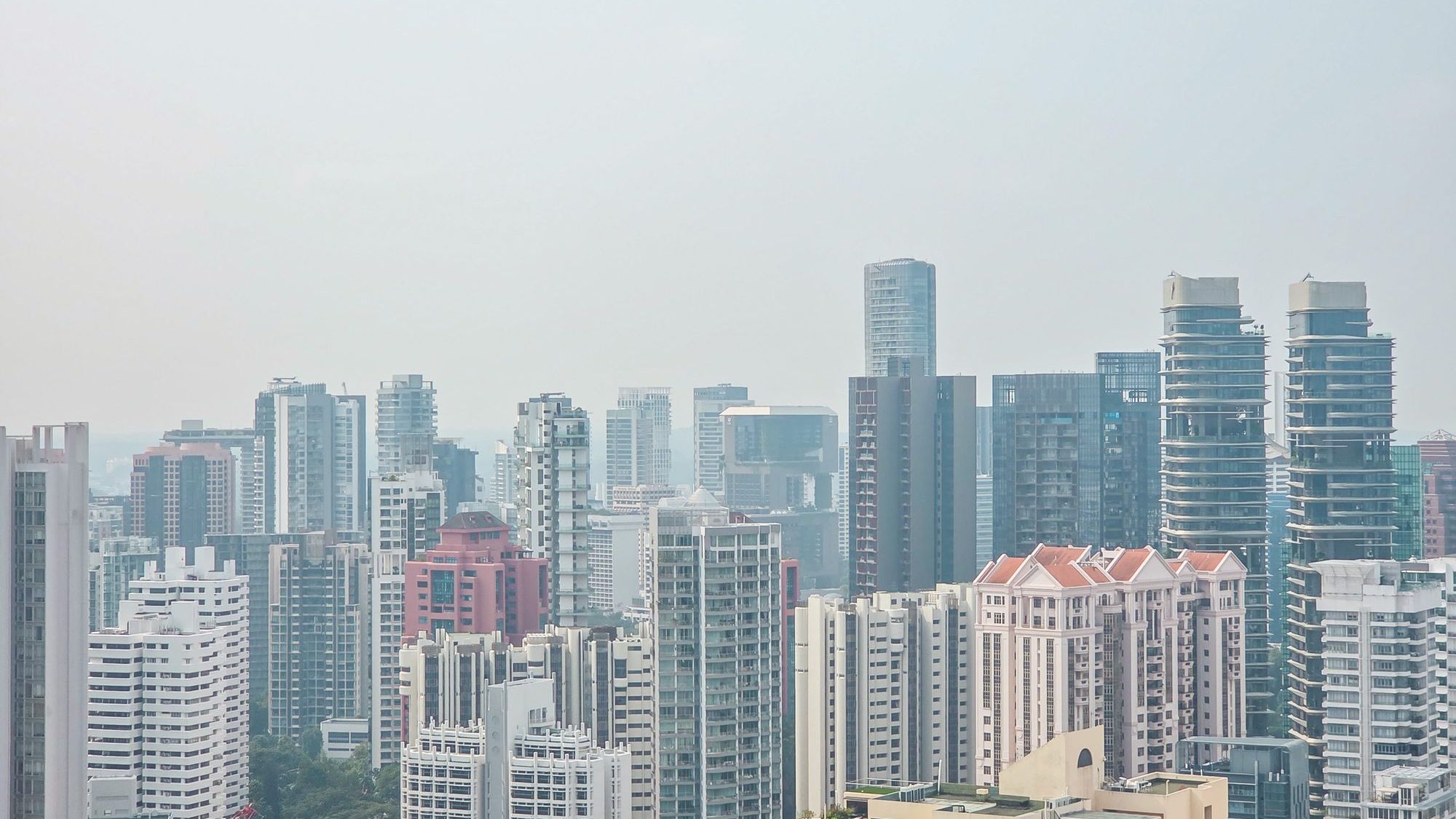 High-rise residential and commercial buildings forming a cityscape under a pale sky