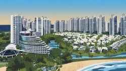 High-rise residential blocks and low-rise houses near a beach with green spaces and waterway